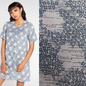Può includere: Un abito a maniche corte, con motivo blu e bianco, con scollo a V.