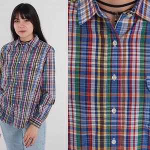 Pode incluir: Uma camisa de bot&otilde;es de manga comprida com um padr&atilde;o xadrez multicolorido. A camisa tem uma gola cl&aacute;ssica e um bolso no peito.