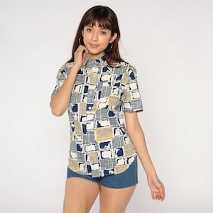 May include: A short-sleeved button-down shirt with a geometric pattern in shades of blue and yellow on a white background.