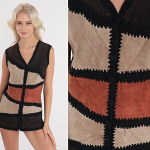 K&ouml;nnte beinhalten: Eine braune, schwarze und rostfarbene Wildlederweste mit H&auml;kelbesatz. Die Weste hat einen Knopfschlie&szlig;e vorne und ein geometrisches Patchwork-Design.