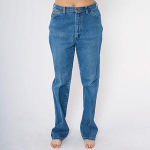 May include: A pair of blue denim jeans with a straight leg fit. The jeans have a high waist and a classic five-pocket style.