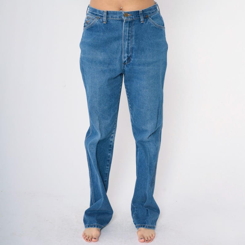 May include: A pair of blue denim jeans with a straight leg fit. The jeans have a high waist and a classic five-pocket style.