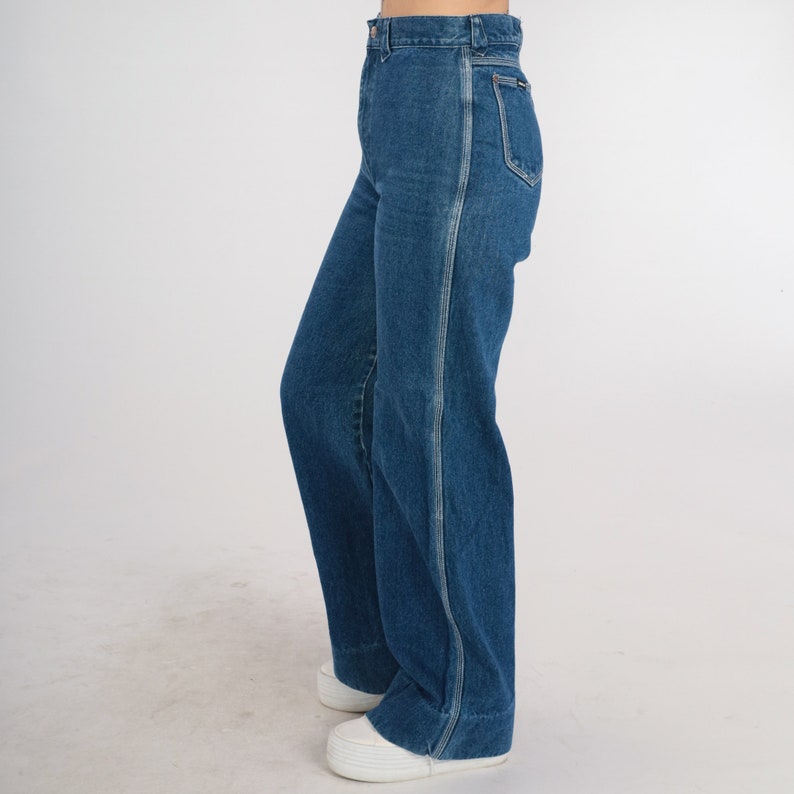 May include: A pair of blue denim jeans with a high waist and a wide leg. The jeans have a straight seam down the outside of each leg.