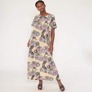 May include: A long, yellow, pink, green, and gray floral print dress with short sleeves.