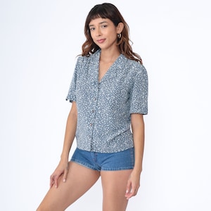 May include: A blue and white patterned short-sleeved button-up shirt with a collared neckline. The shirt has a relaxed fit and is made of a lightweight fabric.