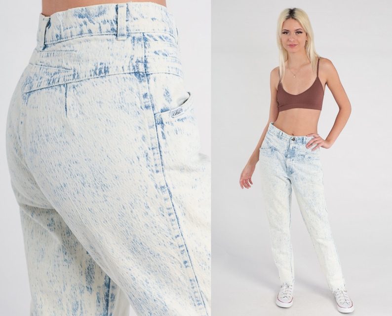 May include: High-waisted acid wash jeans in a light blue colour with a faded look. The jeans have a relaxed fit and a straight leg.