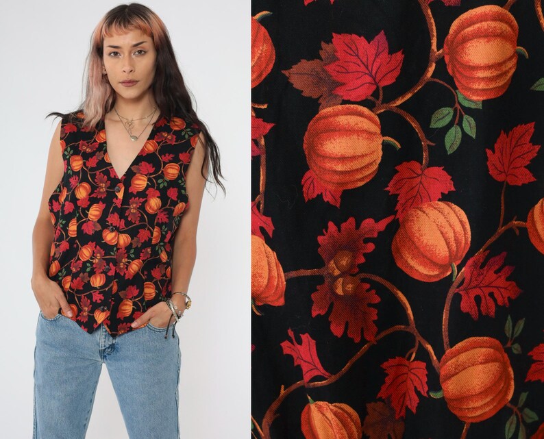 Puede incluir: Un chaleco negro sin mangas con un estampado de oto&ntilde;o de calabazas naranjas y hojas rojas. El chaleco tiene cuello en V y cierre de bot&oacute;n.