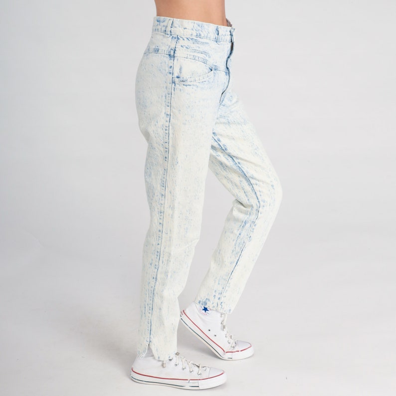 May include: A pair of light blue acid wash jeans with a high waist and a straight leg fit. The jeans are made of a soft, comfortable denim and have a distressed look.