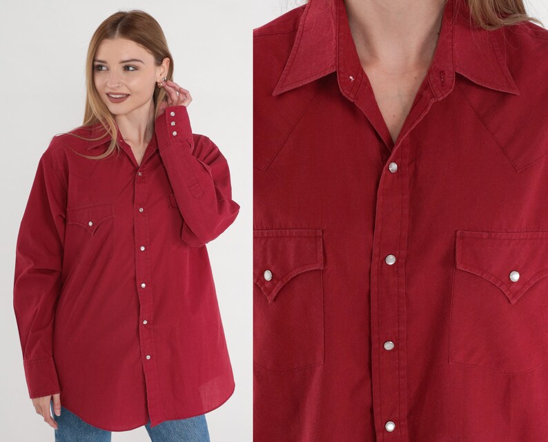 May include: A red long-sleeved button-down shirt with a pointed collar and two chest pockets. The shirt has a classic Western style.