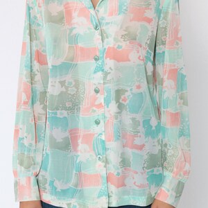 Puede incluir: Camisa abotonada con estampado de bloques de color pastel. La camisa tiene cuello y mangas largas. La paleta de colores incluye tonos de verde menta, melocot&oacute;n y blanco, creando una est&eacute;tica suave y vintage.