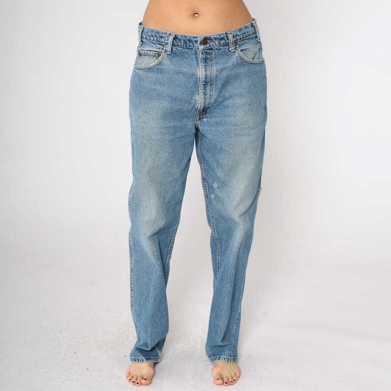 May include: A pair of light blue denim jeans with a straight leg fit. The jeans have a faded wash and a slightly distressed look.