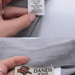 May include: Gray sleeveless top with a small size tag and a label that reads "DANESI JEANS MADE IN U.S.A."