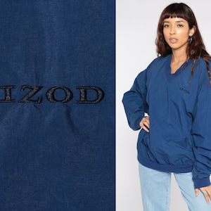 Puede incluir: Una sudadera azul con cuello en V y mangas largas. La sudadera tiene la palabra "IZOD" bordada en la parte delantera.