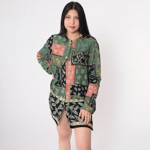 May include: A long-sleeved button-up shirt with a patchwork design featuring green, black, and pink geometric patterns.