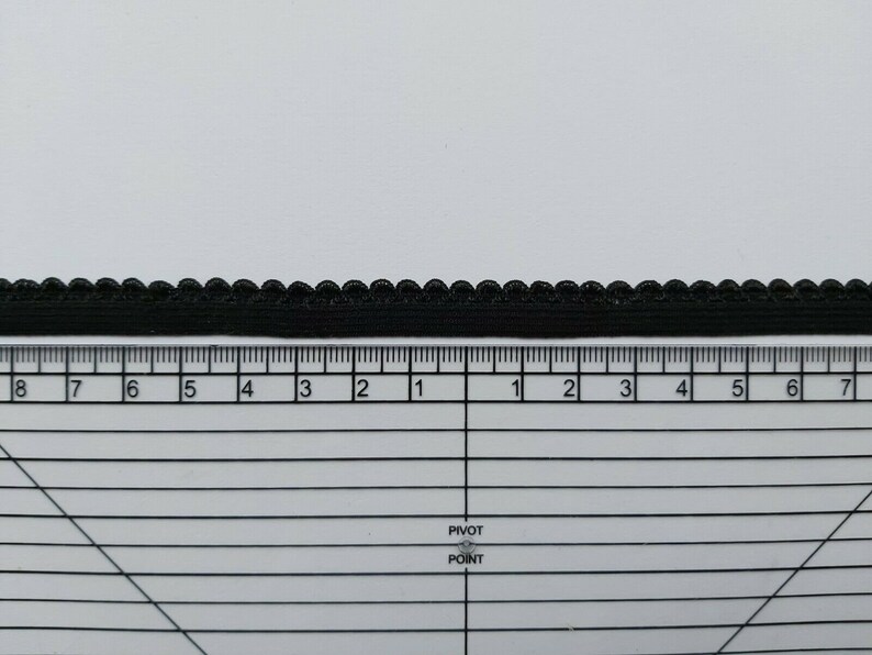 Pu&ograve; includere: Finitura elastica nera con bordo a festoni. La finitura &egrave; misurata con un righello con segni in pollici.