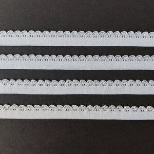 Pu&ograve; includere: Quattro pezzi di bordino elastico bianco con bordo a festoni. Il bordino &egrave; largo circa 1,2 cm.