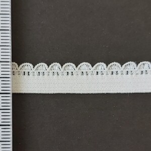 Pu&ograve; includere: Finitura elastica bianca con bordo a festoni. La finitura &egrave; larga circa 2,5 cm.