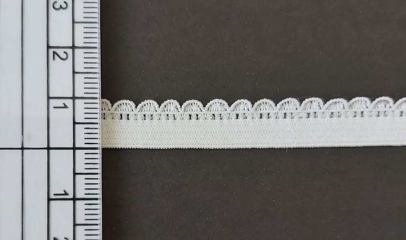 Pu&ograve; includere: Finitura elastica bianca con bordo a festoni. La finitura &egrave; larga circa 2,5 cm.