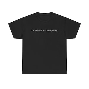 Może przedstawiać: Czarny T-shirt z nadrukiem "cat /dev/null > ~/.bash_history" w kolorze białym.