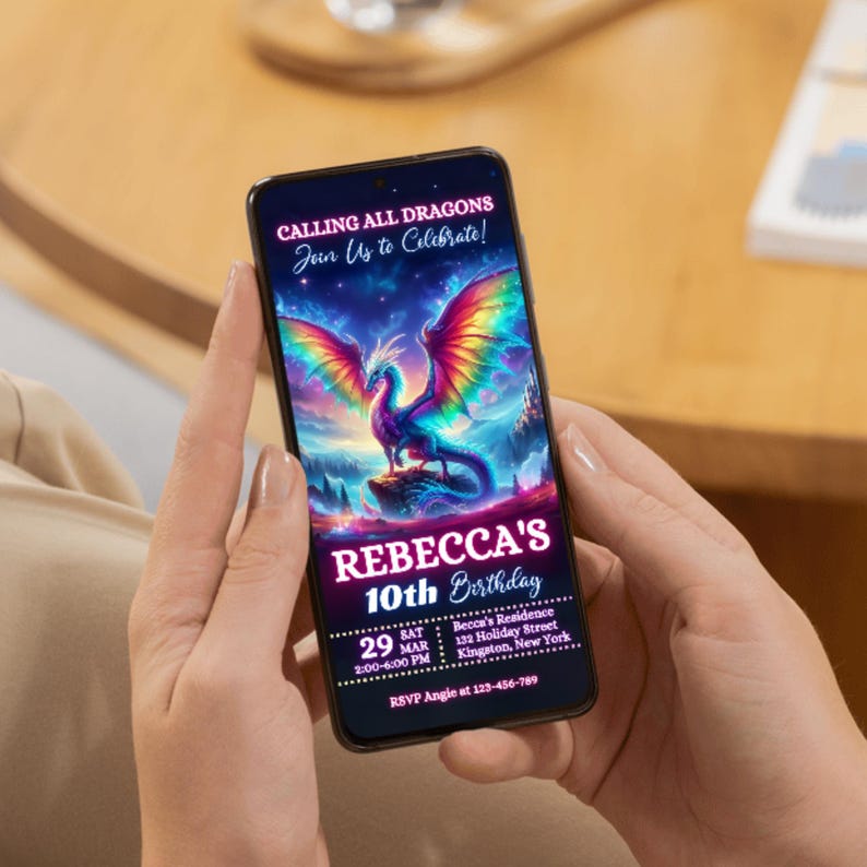 Peut inclure: Un smartphone affiche une invitation d'anniversaire avec un th&egrave;me fantastique. Le texte indique "APPEL &Agrave; TOUS LES DRAGONS, Rejoignez-nous pour c&eacute;l&eacute;brer !" et "10e anniversaire de REBECCA." L'invitation pr&eacute;sente un dragon aux ailes arc-en-ciel.