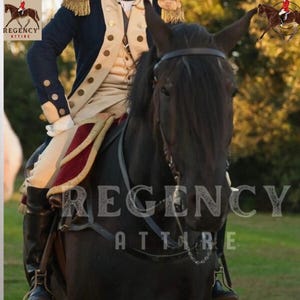 Op de afbeelding: Een zwart paard met een lederen hoofdstel en een ruiter in een blauw en beige jas. Het paard staat op een grasveld met bomen op de achtergrond. De tekst "Regency Attire" is zichtbaar in de afbeelding.