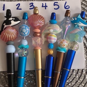 May include: A set of three ceramic nesting bowls in shades of blue, green, and white. The bowls feature a speckled glaze and a simple, modern design. The largest bowl measures approximately 8 inches in diameter.