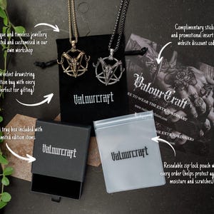 Pode incluir: Dois colares com pingente com um design de pentagrama e cabe&ccedil;a de bode, um dourado e outro prateado, apresentados com uma bolsa de veludo preta, uma caixa de marca e um encarte promocional. A marca "Valourcraft" &eacute; vis&iacute;vel.