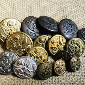 Peut inclure: Une collection de boutons militaires vintage représentant le sceau des États-Unis en finitions or, argent et bronze.