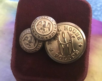May include: Three gold-colored metal buttons with different designs. The first button features an eagle with the text "Metropolitan Police D.C.". The second button features an eagle with the text "Metropolitan Police D.C.". The third button features the text "White House Police".