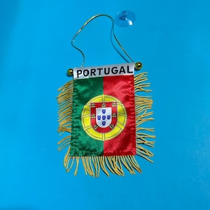 Peut inclure: Un drapeau rectangulaire en tissu du Portugal avec un design vertical divisé en vert et rouge et les armoiries nationales au centre. Le mot PORTUGAL est imprimé en noir sur une barre blanche. Il possède des franges dorées et une ventouse.