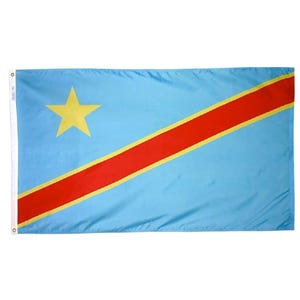 May include: A rectangular flag featuring a light blue background with a yellow star in the upper left corner. A red stripe with yellow borders diagonally crosses the flag. The flag is likely made of a lightweight fabric.