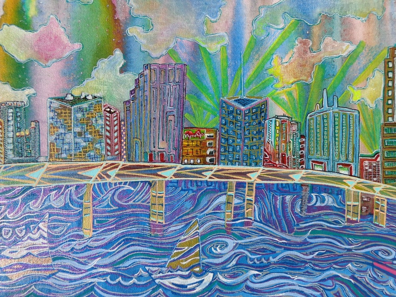 May include: A colorful painting of a city skyline with buildings reflected in a blue and purple river. The sky is a mix of pink, green, and yellow with clouds.