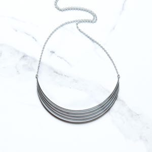 Zilveren boogketting, gestroomlijnde combinatie van vijf rechthoekige sterlingzilveren draden gevormd tot een sculpturale halve maanvorm - "Fleet Necklace"