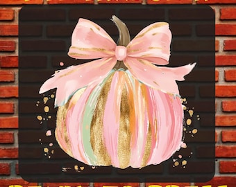 May include: A DTF transfer ready to press featuring a pumpkin illustration with vertical pink, gold, and light green brushstroke stripes. A large, light pink bow with gold accents sits atop the pumpkin stem. The text DTF TRANSFER and READY TO PRESS appears in yellow.
