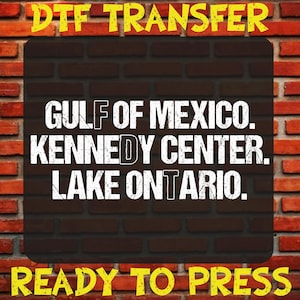May include: A DTF transfer sheet featuring the white text GULF OF MEXICO, KENNEDY CENTER, LAKE ONTARIO in a distressed font style. The words DTF TRANSFER and READY TO PRESS are printed in yellow at the top and bottom of the rectangular design.