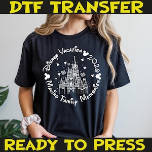 K&ouml;nnte beinhalten: Schwarzes T-Shirt mit wei&szlig;er Grafik, die ein Schloss, Mickey Mouse-Silhouetten und den Text "Disney Vacation 2026 Making Family Memories" zeigt. Die W&ouml;rter "DTF TRANSFER" und "READY TO PRESS" sind gelb gedruckt.