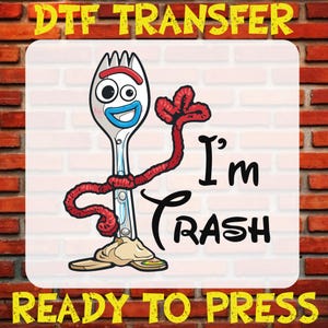 May include: A white and blue fork with a red yarn body and arms. The fork has a cartoon face with a blue smile and large eyes. The fork is standing with its arms raised and the text "I'm Trash" is written in black below it. The image is labeled "DTG Transfer Ready to Press".