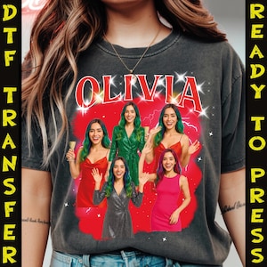 Peut inclure: T-shirt gris foncé avec le nom "OLIVIA" en rouge, entouré d'éclairs. Le t-shirt présente un graphisme de cinq femmes en robes et coiffures variées, sur fond rouge. Les mots "DTF TRANSFER" et "READY TO PRESS" sont imprimés verticalement sur les côtés.