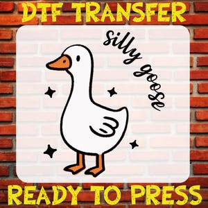 May include: A white goose with a black outline and orange beak, with the text "silly goose" written in black cursive above it. The image is on a white background with a brick wall border and the text "DTG TRANSFER READY TO PRESS" in yellow at the top and bottom.
