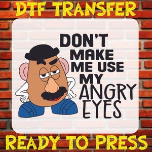 May include: A DTF transfer design featuring a cartoon Mr. Potato Head with the text "DON'T MAKE ME USE MY ANGRY EYES." The design is ready to press and set against a brick wall background.