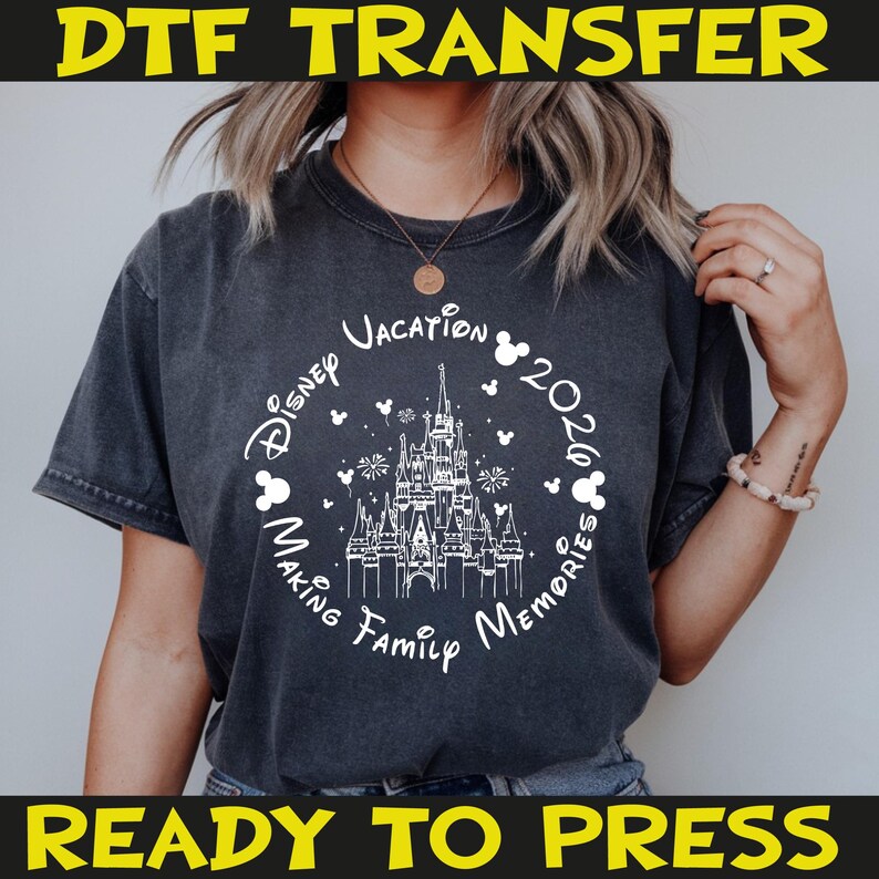 K&ouml;nnte beinhalten: Dunkelgraues T-Shirt mit wei&szlig;er Grafik, die ein Schloss, Mickey-Mouse-Silhouetten und den Text "Disney Vacation 2020 Making Family Memories" zeigt. Die W&ouml;rter "DTF TRANSFER" und "READY TO PRESS" sind ebenfalls abgebildet.
