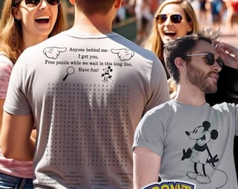 May include: A group of people in a theme park, some wearing gray t-shirts. One shirt has a Mickey Mouse graphic, another has a word search puzzle with the text "Anyone behind me - I got you, Free puzzle while we wait in this long line, Have fun!"