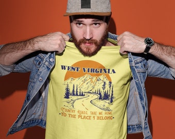 May include: A yellow t-shirt with a graphic of a mountain range and a winding road. The text "West Virginia" is above the graphic and the text "Country Roads, Take Me Home. To The Place I Belong." is below the graphic.