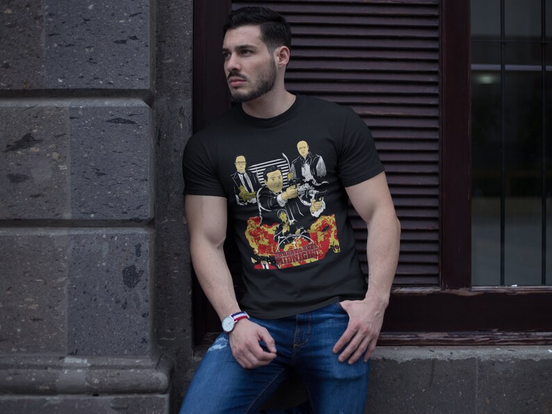 Peut inclure: Un t-shirt noir avec un imprim&eacute; graphique de quatre hommes en costume. Le graphique comprend le texte "Goodfellas" et "Midnight Hour".