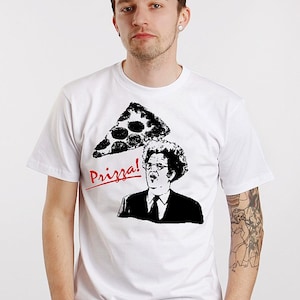 May include: White t-shirt with a black and white illustration of a man with a pizza slice over his head. The text "Prizza!" is written in red.