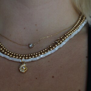 White pearl beaded necklace with gold seashell charm