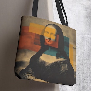 May include: Tote bag featuring a stylized image of the Mona Lisa with geometric shapes in orange, yellow, and blue overlaid on the portrait. The bag has black straps and a neutral background.