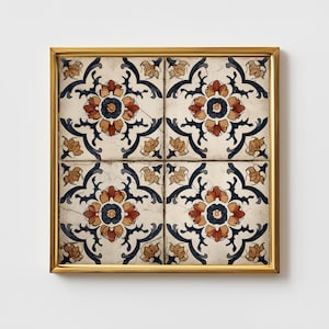 Könnte beinhalten: Ein quadratisches Wandbild aus vier Keramikfliesen in einem goldenen Rahmen. Die Fliesen zeigen ein sich wiederholendes Muster aus dunkelblauen, rostorangen und beigen Blumenmotiven auf cremefarbenem Grund mit sichtbarer Craquelé-Glasur.