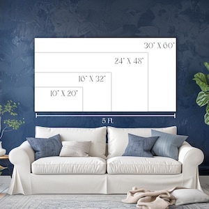 May include: A white canvas with size options: 76 cm x 152 cm, 61 cm x 122 cm, 41 cm x 81 cm, and 25 cm x 51 cm. The canvas is displayed above a white sofa with blue cushions. The wall is dark blue. A plant is in the background.