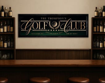 May include: A rectangular sign with the words "THE THOMPSON'S GOLF CLUB" in gold lettering. The sign features a golf ball graphic and the text "WELCOME TO" and "THE 19TH HOLE". The sign is above a bar with stools and shelves of wine bottles.